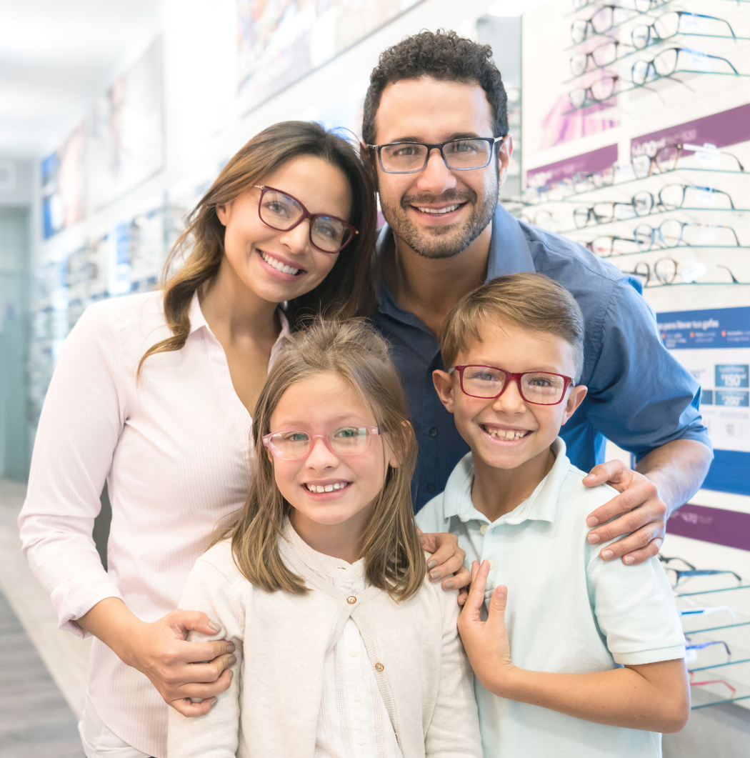 Latin American family trying on glasses at the optical shop